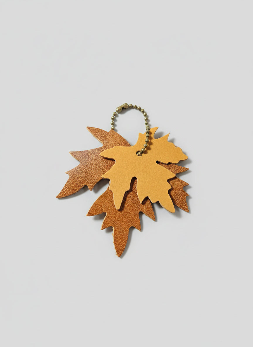 Leather leaf keychain on a dark surface with a tool in the background