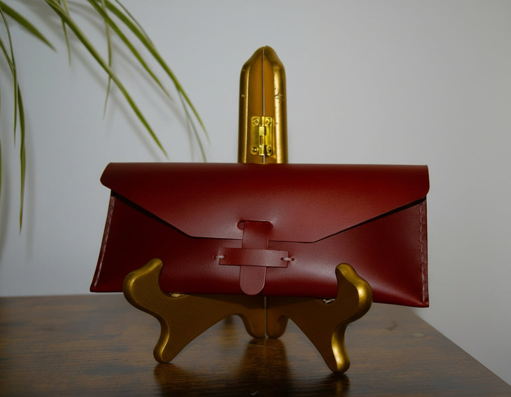 Red leather case on a gold stand with a blurred plant in the background